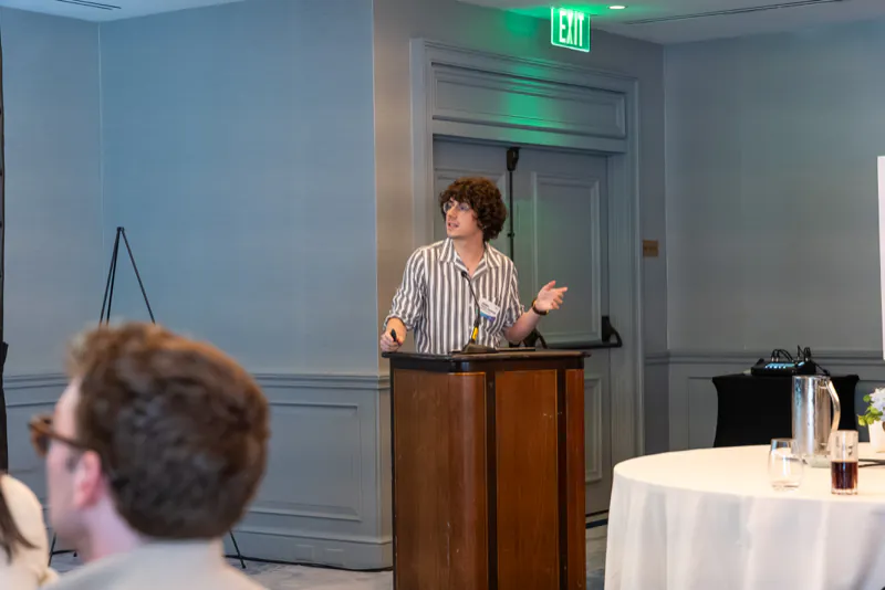 A presenter speaking from the podium while attendees listen